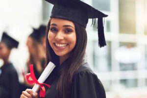 usmiechnięta studentka trzymająca dyplom